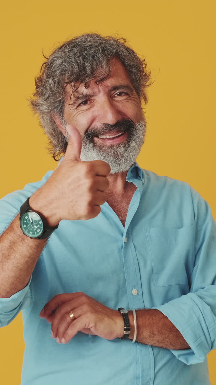 Smiling Mature Man Giving Thumbs Up Gesture