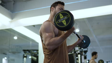 atleta haciendo ejercicio con una barra de rizado en un gimnasio cubierto