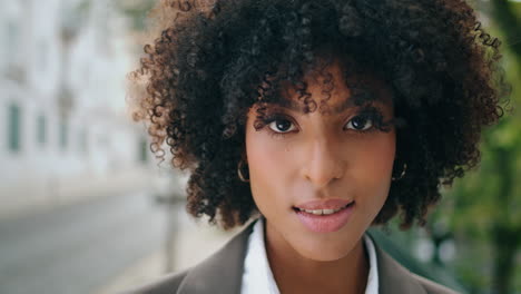 sensual girl face looking camera with light smile close up. portrait curly woman