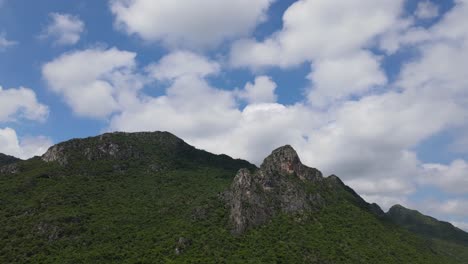 un metraje constante de esta roca en una montaña de piedra caliza con nubes esponjosas y cielo azul