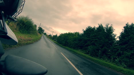 biker riding a motorcycle in the countryside through farms and open roads in scotland