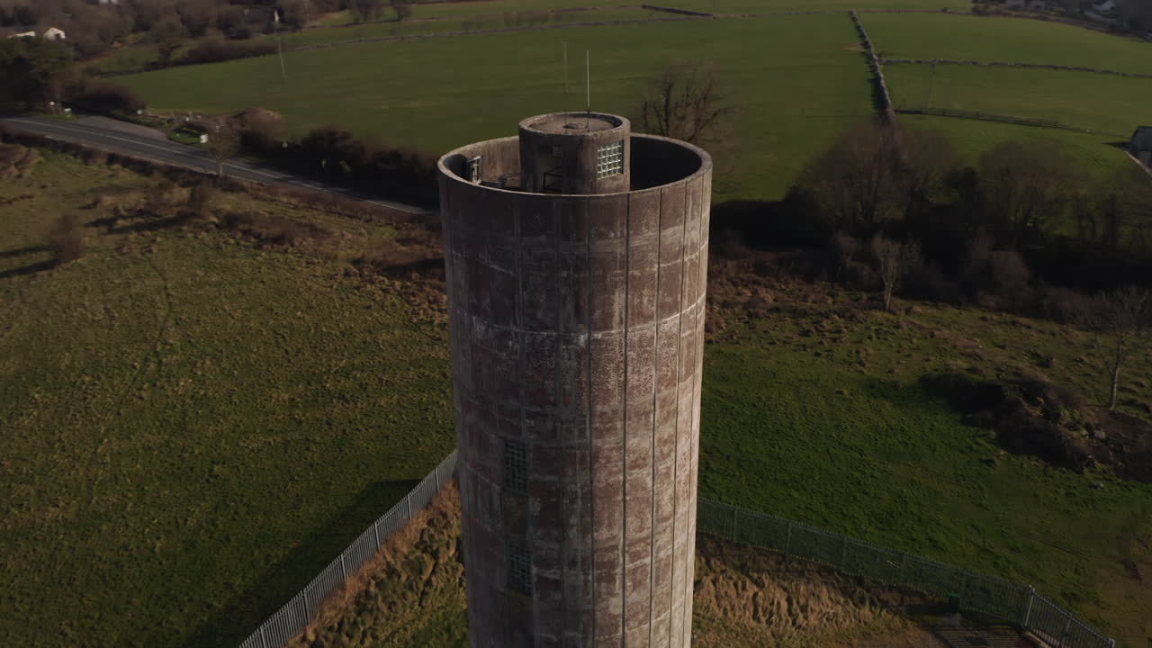 Close-up shot of a tall water tower, highlighting its intricate architectural details and design.