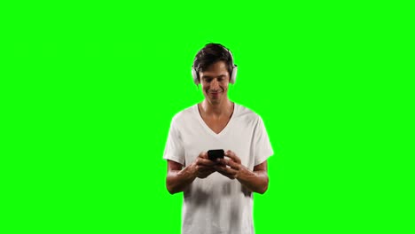 Front-view-of-a-Caucasian-man-listening-music-with-green-screen