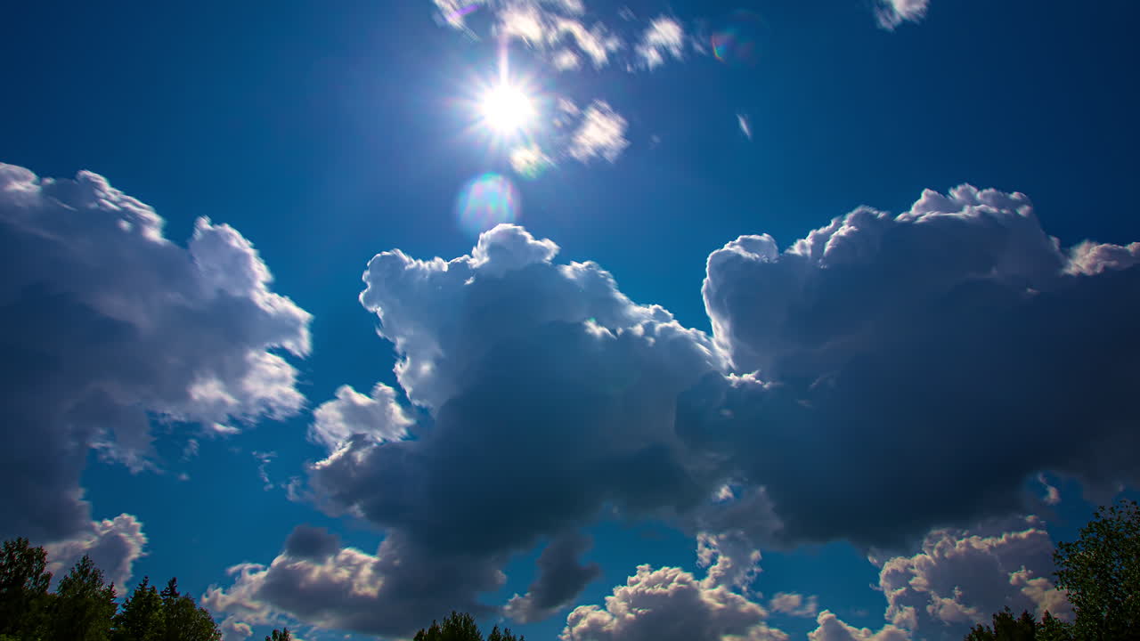 푸른 하늘에 태양이 밝게 빛나고 구름이 사방으로 움직인다