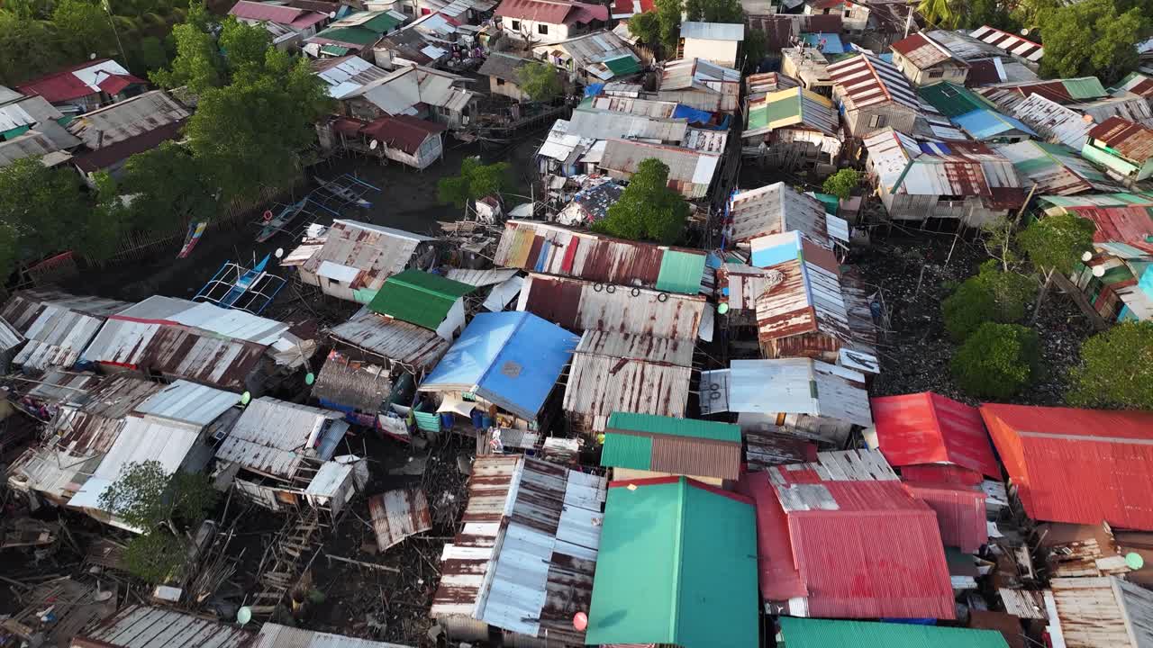 Drone close up over slum fishing village house roofs. Coron, Phillippines, reveal to mountain.
