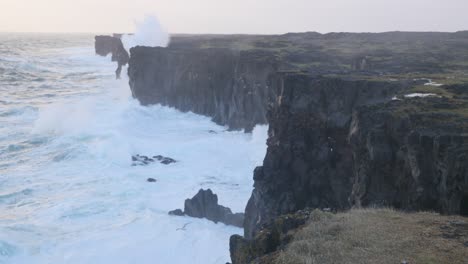 waves crashing on basalt cliffs by the arnarstapi in snaefellsnes peninsula, iceland