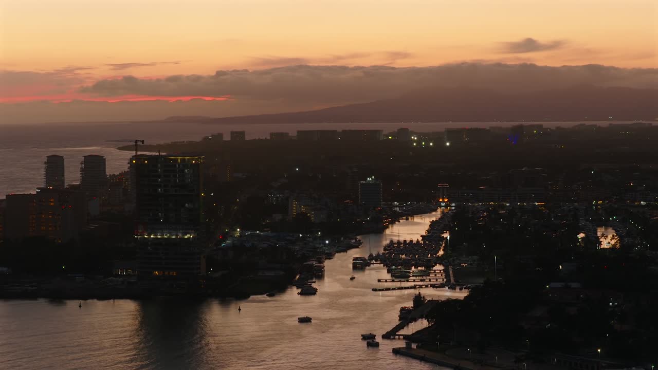 Marina Vallarta cruise port with boats docked, surrounded by city buildings, mountains and ocean. Puerto Vallarta, Mexico
