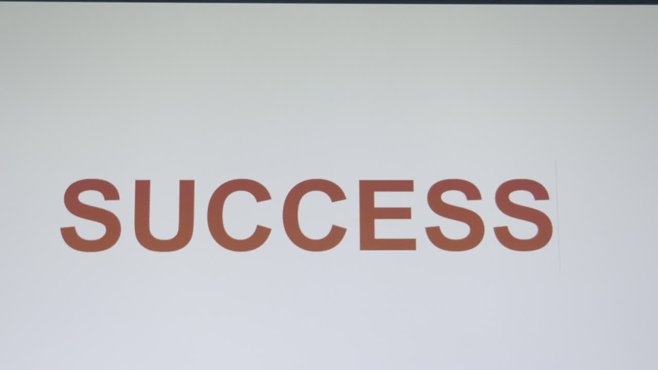 Markør bevæger sig til højre og afslører bogstaver fra et stort S for at fuldende ordet SUCCESS, mens en person taster på et tastatur eller skriver en tekstbesked