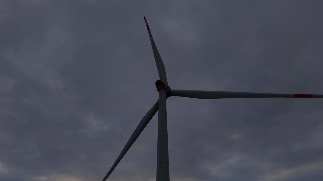 Majestic wind turbine stands tall against a dramatic sky at dusk, capturing the essence of renewable energy and nature's power
