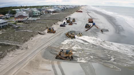 coastal erosion restoration project bulldozers on beach pushing sand onto shore from 4k aerial drone view