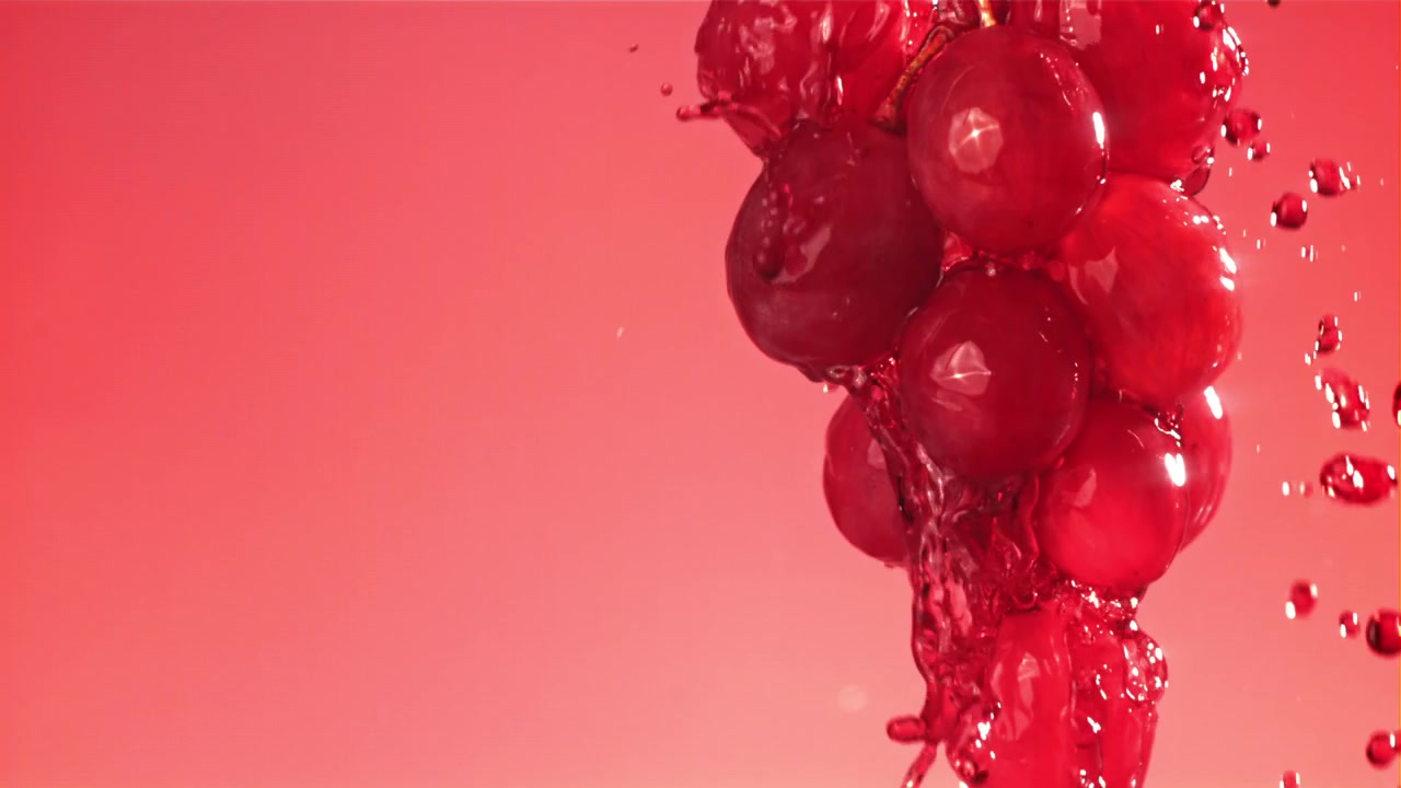 Fresh Red Grapes Splashing with Red Liquid in Slow Motion