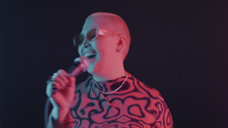 woman singing with microphone under neon lighting