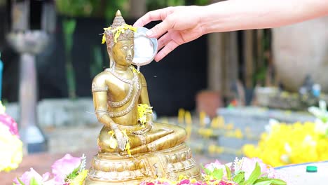 sequential pouring of water on a buddha statue