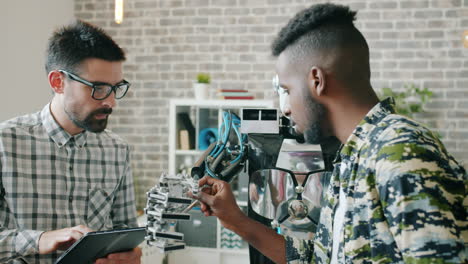 two engineers working with a robot