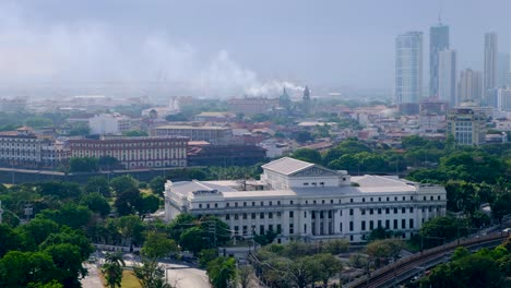 aerial view of smoke billowing across intramuros walled city on hazy smoggy day in capital city of manila philippines
