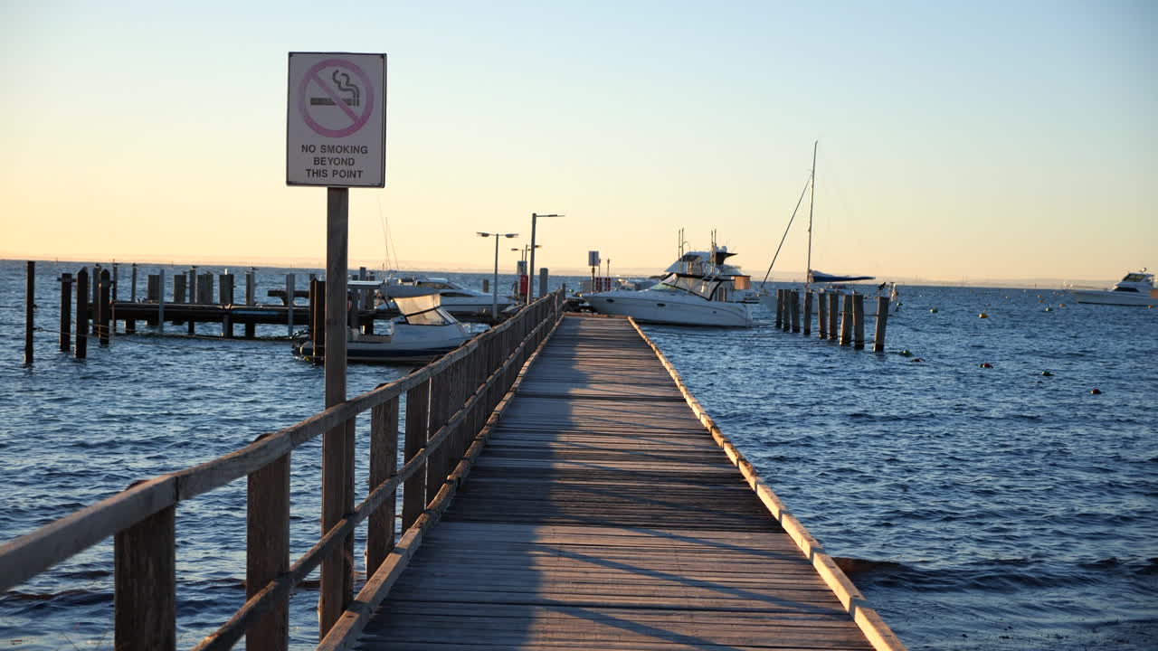 Pan across sunny wharf-pier with boats