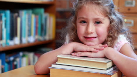 niña sonriendo a la cámara en la biblioteca