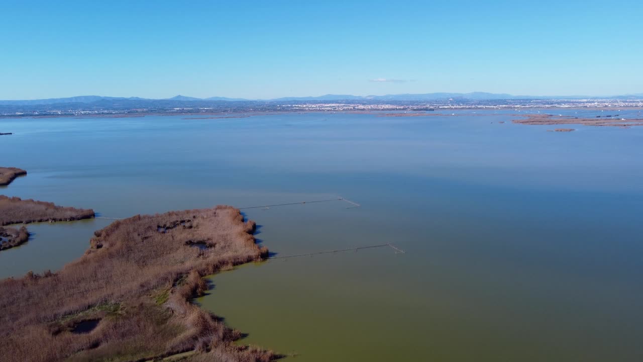 4K Drone View of Albufera Lagoon in Valencia with Multi-toned Water and Distant Mountains