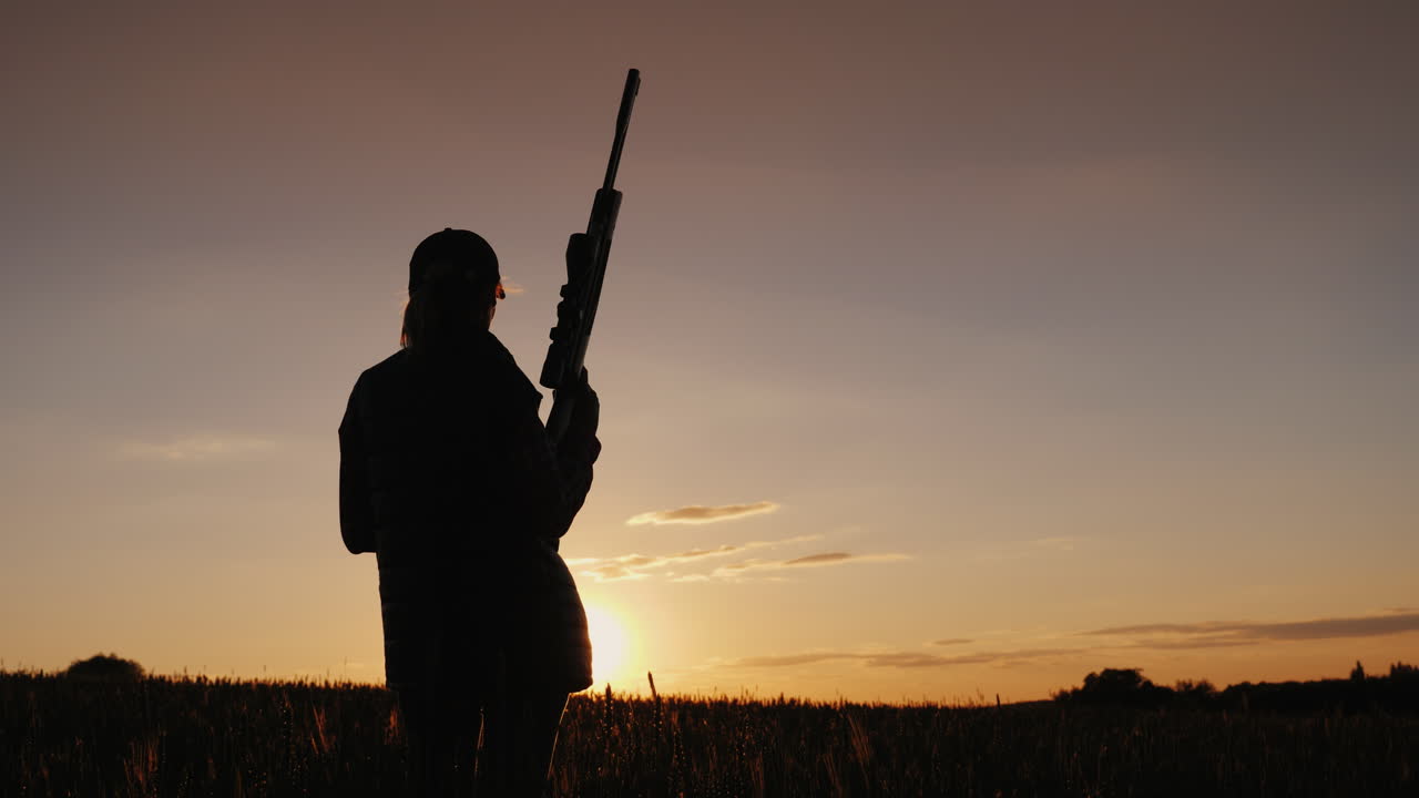 A Female Athlete With A Gun Looks Ahead At The Sunset Women's Sports Shooting Concept Rear View