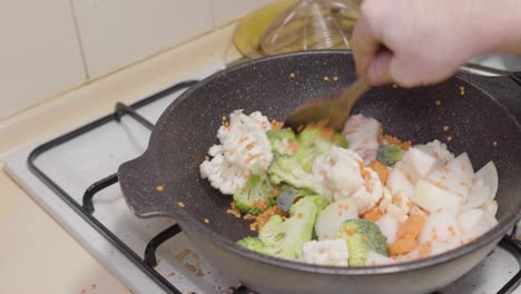 Mixing-stir-fry-vegetables-soup-and-lentils-home-cook-wooden-spoon