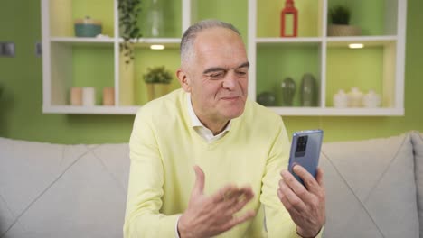 Elderly-retired-man-talking-facetime-with-loved-ones-at-home.