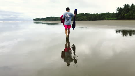 whale tale national park, costa rica caucasian male walking on flat water with stunning reflection