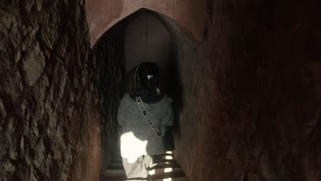 una mujer explora un túnel subterráneo estrecho y débilmente iluminado, mirando hacia arriba, una sensación de descubrimiento
