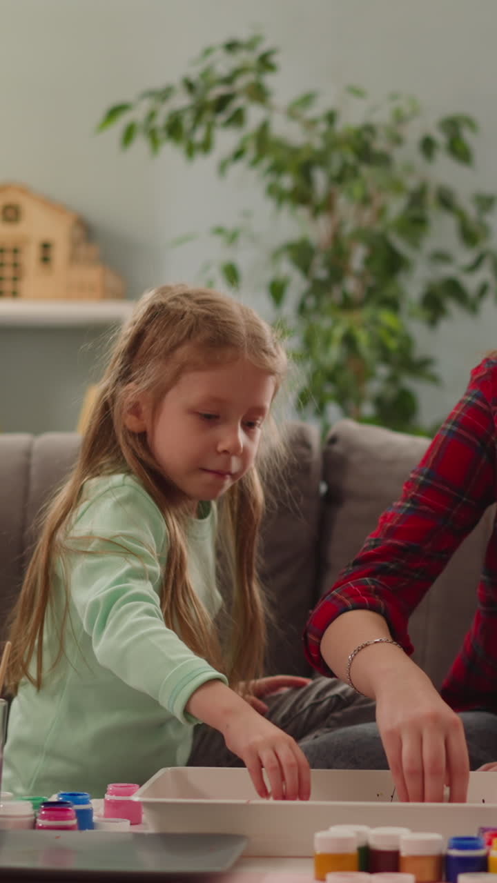 familia de adolescentes y niñas pequeñas colorean huevos para las vacaciones de pascua con la técnica ebru en cámara lenta. ideas y tradiciones de decoración de vacaciones cristianas