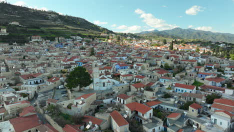 Aerial-snapshot-of-the-traditional-village-of-Lefkara,-Cyprus,-with-its-characteristic-red-tiled-roofs,-narrow-streets,-and-a-church-in-the-center,-surrounded-by-the-rolling-hills-of-the-countryside