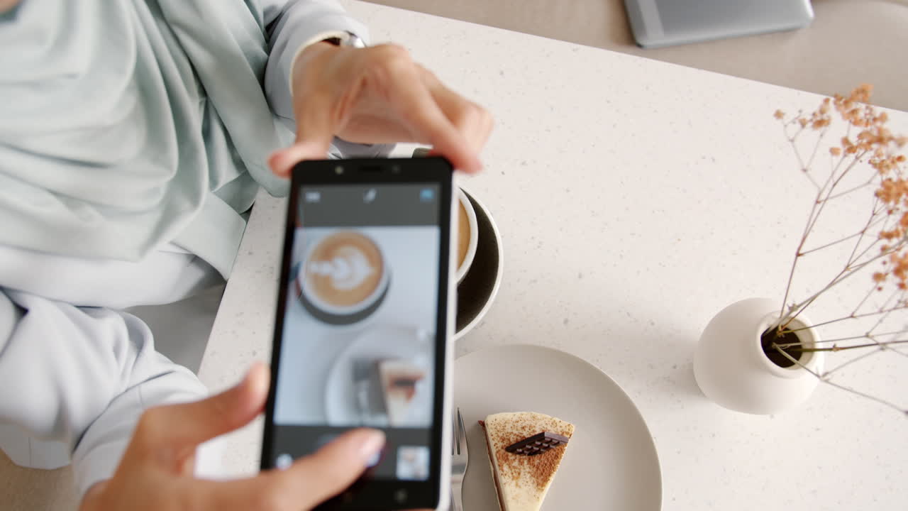 Woman Taking Photo of Coffee and Cake at Cafe