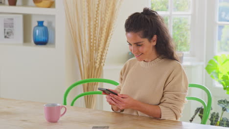 Celebrando-A-Una-Mujer-Con-Tarjeta-De-Crédito-En-Casa-Usando-Un-Teléfono-Móvil-Para-Realizar-La-Compra-De-Sus-Sueños