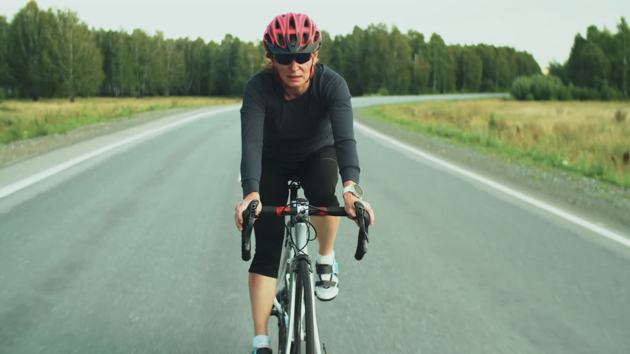 mujer atlética montando bicicleta en la carretera