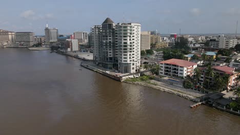 A-drone-showcases-the-luxurious-Black-Diamond-Suites-and-Apartments-perched-at-the-edge-of-Five-Cowries-Creek-in-the-vibrant-city-of-Lekki,-Lagos,-Nigeria