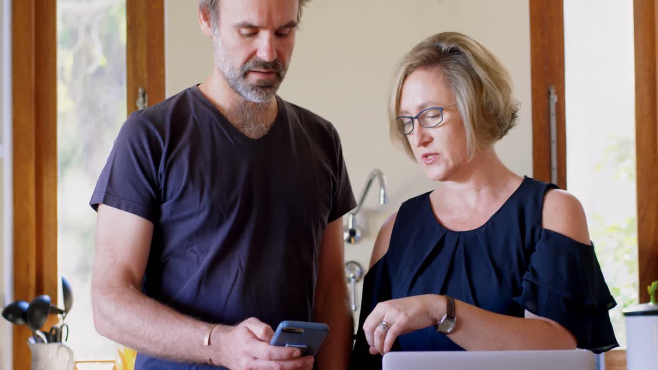 pareja usando teléfono móvil en la cocina 4k