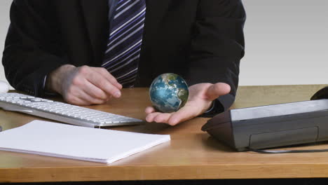 businessman with a rotary terrestrial globe in his open hand