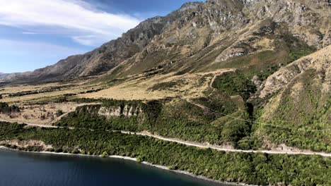 Winding-road-around-lake-Wakatipu,-favourite-holiday-spot,-South-Island,-New-Zealand---aerial