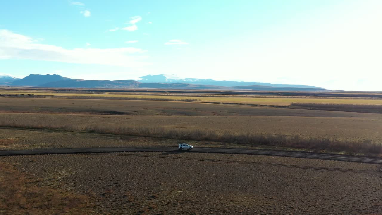 volando por encima del automóvil conduciendo fuera de la carretera en el campo de islandia, tiro de seguimiento