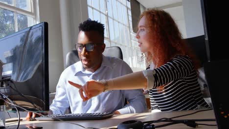 front view of young mixed-race business team planning and working on desktop pc in modern office 4k