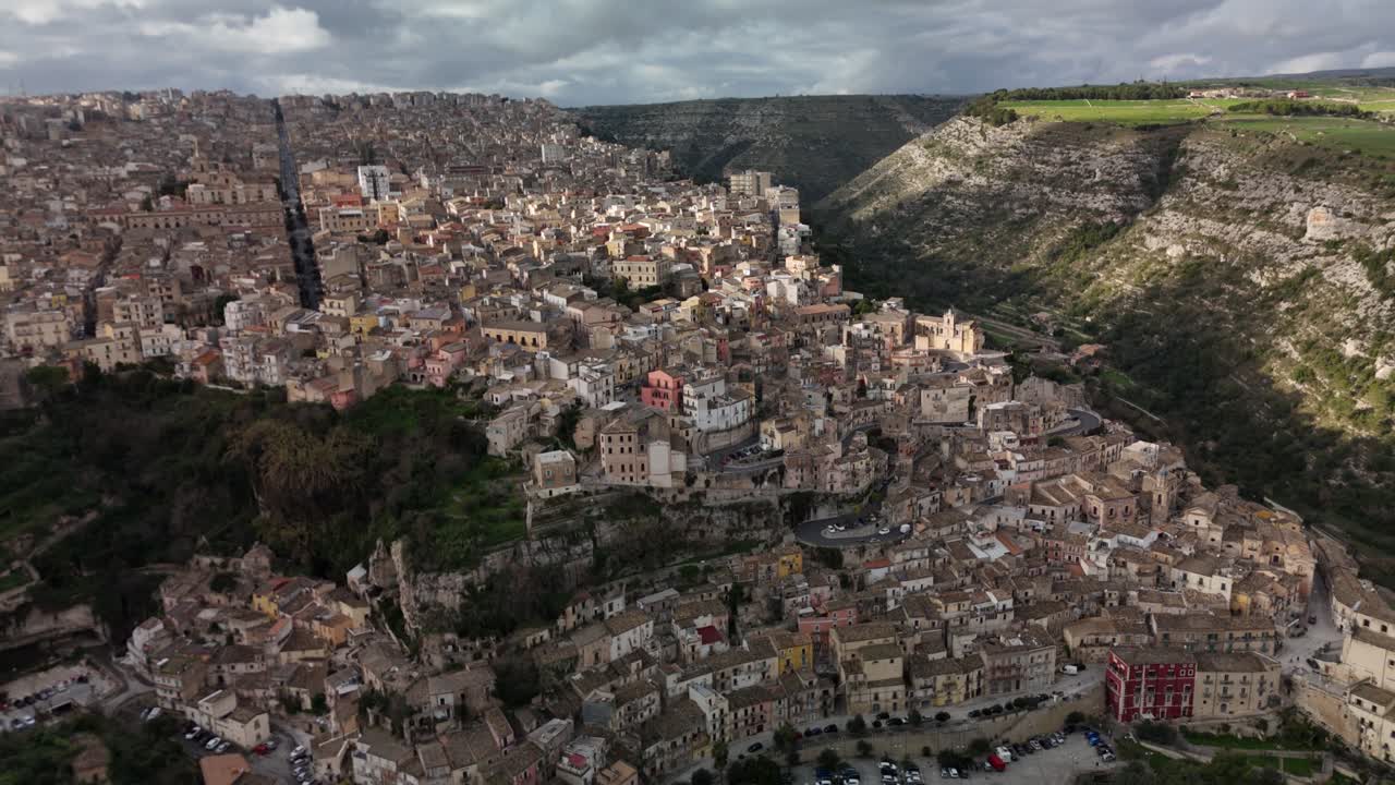 Vista aérea de una histórica ciudad italiana ubicada entre colinas y valles ondulantes