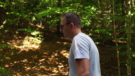 man walking through forested landscape near sfânta ana lake in romania - tracking shot