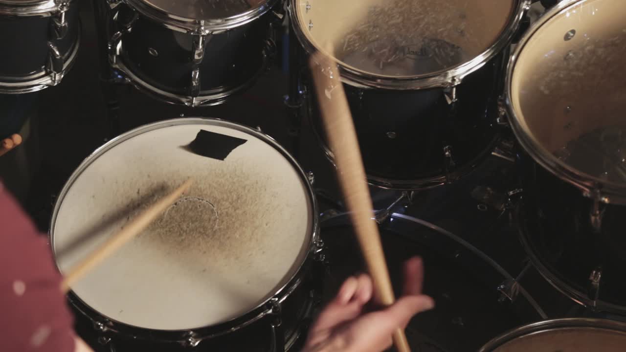 atractivo joven baterista tocando su batería y practicando mientras canta - primer plano