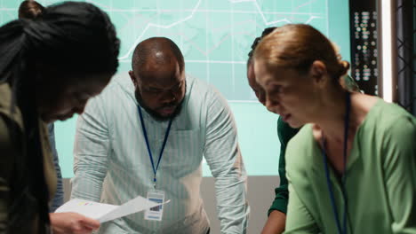 multiethnic team exchanging files and review forecasting diagrams at night
