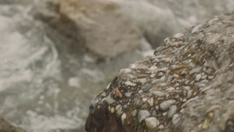 olas del mar chocando contra rocas con superficies ásperas durante el día