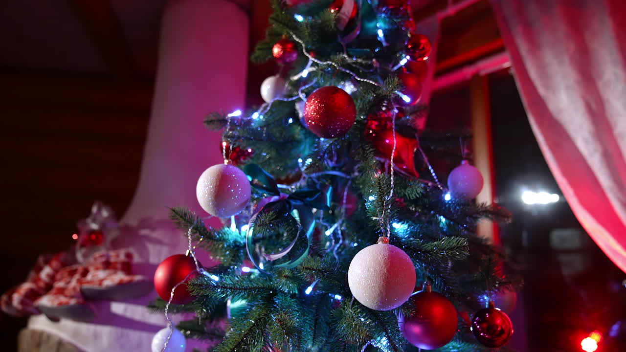 Beautiful Christmas tree indoors. Colorful Christmas balls hanging on New year tree in the living room. Happy winter holidays.