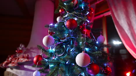 beautiful christmas tree indoors. colorful christmas balls hanging on new year tree in the living room. happy winter holidays.