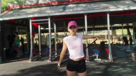 Young woman exercising with resistance band in outdoor gym