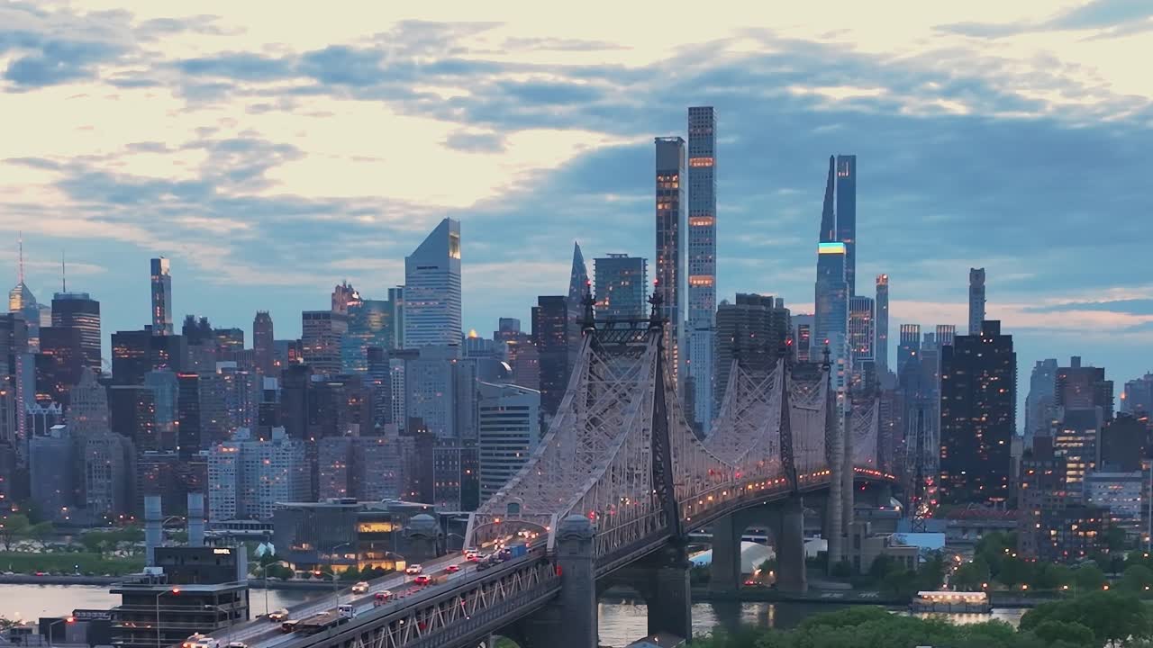 夕暮れ時のニューヨーク市のスカイラインとクイーンズボロ橋の眺め。