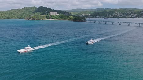 boats cruising out of samana bay with puente de cayo samana in background