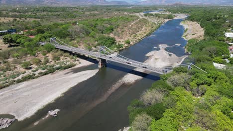 Wide aerial view of bridge over Choluteca River, Honduras, agricultural area