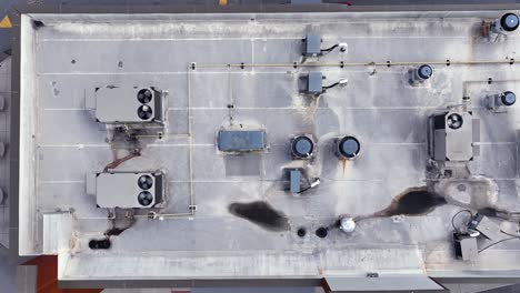 aerial top down shot of rotating propeller of air conditioner on roof of building. hot summer day in america. rising shot. global warming theme.